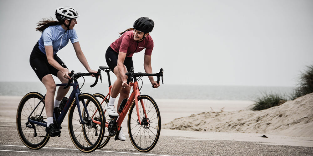twee vrouwelijke wielrenners die aan het fietsen zijn